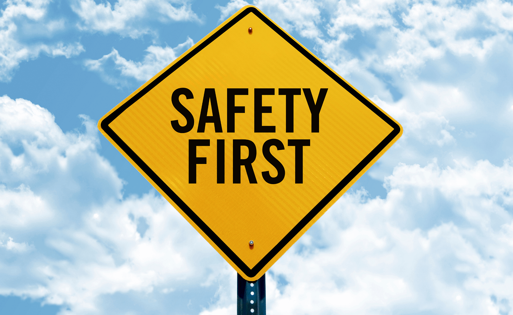 Yellow road sign reading "Safety First" against blue sky